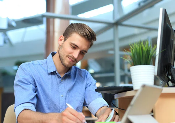 Retrato de belo homem sorridente em camisa casual tomar notas no local de trabalho. — Fotografia de Stock