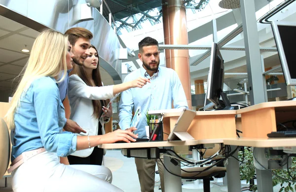 Ofis Masası oturma ve Pc vasıl birlikte bakarken bir şey tartışırken rahat kıyafet içinde gençlerin Grup.