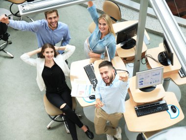 Top view of young modern colleagues in smart casual wear working together while spending time in the office. clipart