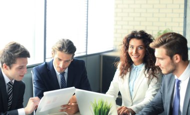 Beyin fırtınası. Birlikte laptop arıyorum iş adamları grubu. Kameraya bakarak bir iş kadını