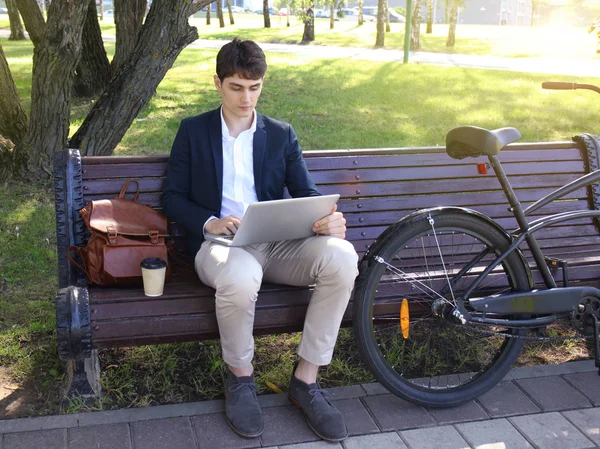 コーヒー休憩ベンチに座って ノート パソコン 自転車の横で働くビジネスマン — ストック写真