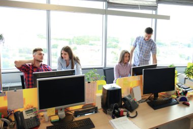 Ekibi ofisinde çalışıyor. Monitör yazmaya ve yeni proje tartışıyor