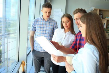 Smart casual modern gençlerin grup giymek bir beyin fırtınası dururken yaratıcı ofiste toplantısı