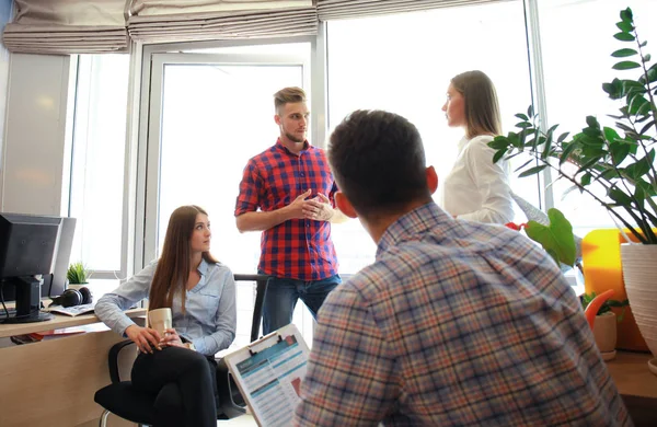 Smart casual modern gençlerin grup giymek bir beyin fırtınası dururken yaratıcı ofiste toplantısı