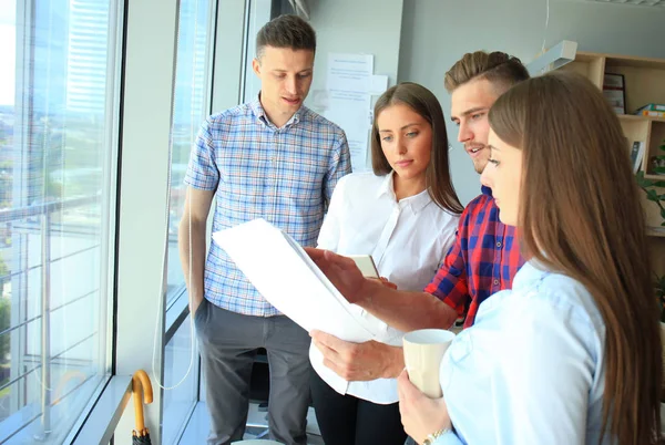 Smart casual modern gençlerin grup giymek bir beyin fırtınası dururken yaratıcı ofiste toplantısı