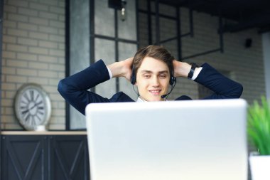 Gülümseyen yakışıklı genç erkek çağrı merkezi operatörü