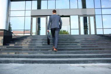 Merdivenlerden yukarı gidiş evrak çantası ile iş yürütme