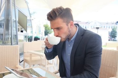 kahve içme ve kafede bir haber okurken iş adamı