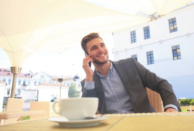 İş adamı ile telefonunu kafede otururken bir fincan kahve içme