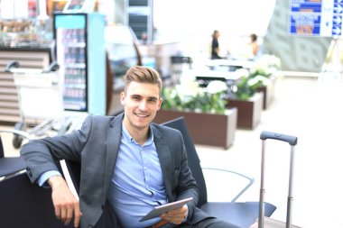 Havaalanı gidiş salonunda dijital Tablet kullanarak iş adamı