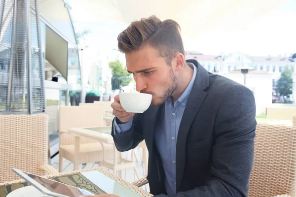 kahve içme ve kafede bir haber okurken iş adamı