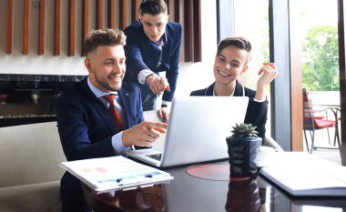 Modern parlak ofiste toplantı ve dizüstü bilgisayarda çalışan iş takım 