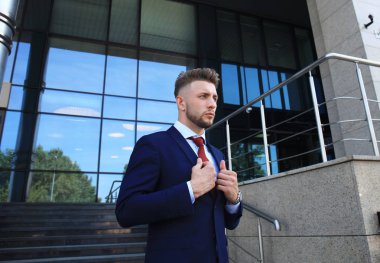 Takım elbise ayakta şehir Binası yakınındaki yakışıklı işadamı portresi