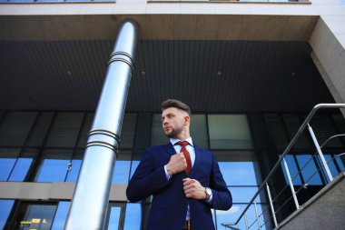 Takım elbise ayakta şehir Binası yakınındaki yakışıklı işadamı portresi