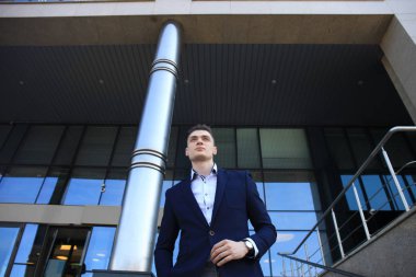 Takım elbise ayakta şehir Binası yakınındaki yakışıklı işadamı portresi