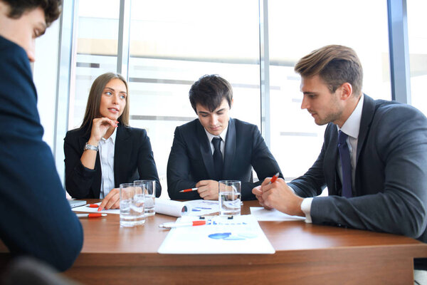 Бизнес-команда анализирует финансовый документ на совещании
