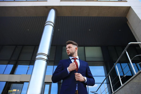 Takım elbise ayakta şehir Binası yakınındaki yakışıklı işadamı portresi