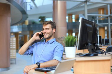 Oturma ve cep telefonu kullanma office işadamı gülümseyen.