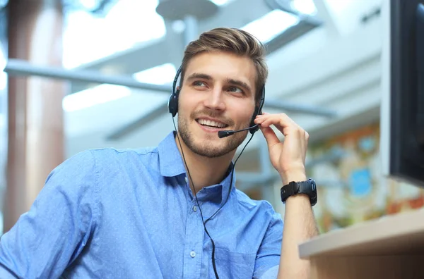 Freundlich lächelnde hübsche junge männliche Callcenter-Betreiber. — Stockfoto