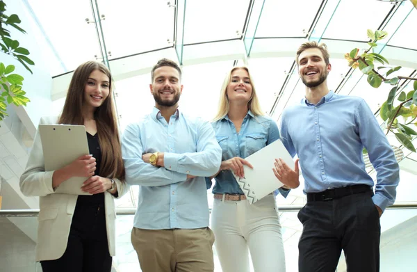 Unga moderna kollegor i smarta casual wear tittar på kameran stående i det kreativa kontoret. — Stockfoto