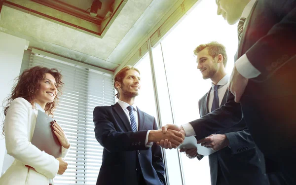 Empresários apertando as mãos, terminando uma reunião. — Fotografia de Stock