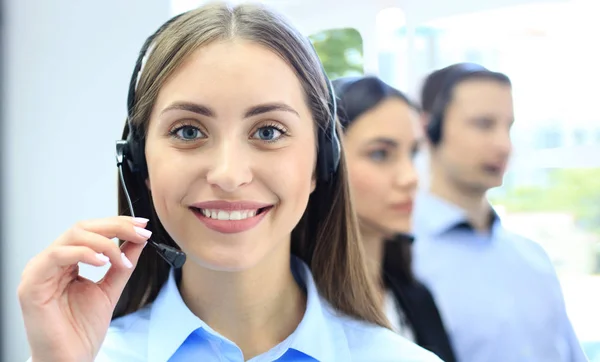 Retrato del trabajador del centro de llamadas acompañado por su equipo. Sonriente operador de atención al cliente en el trabajo. — Foto de Stock
