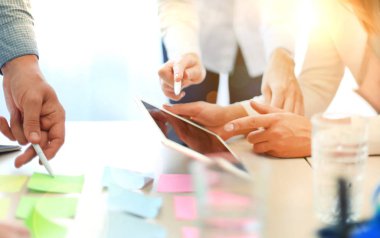 Dijital bir tablet üzerinde kendi iş finansal durumunu tartışırken iş arkadaşları.