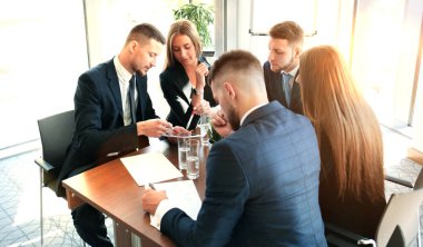 Girişim ekibi, modern parlak ofis içi beyin fırtınası, dizüstü bilgisayar ve tablet bilgisayar üzerine toplantı üzerine çalışıyor.