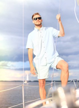 Mutlu tatil Yelkenli Yat ayakta bir güverte üzerinde rahatlatıcı adam.