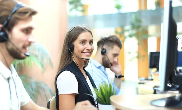 Atractivos jóvenes empresarios y colegas positivos en una oficina de call center. — Foto de Stock