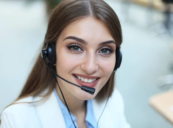 Woman customer support operator with headset and smiling.