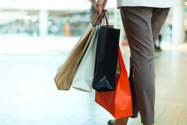 Mão de mulher jovem com sacos de compras com compras . — Fotografia de Stock
