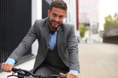 Yakışıklı genç işadamı binicilik bisiklet açık havada şehirde.