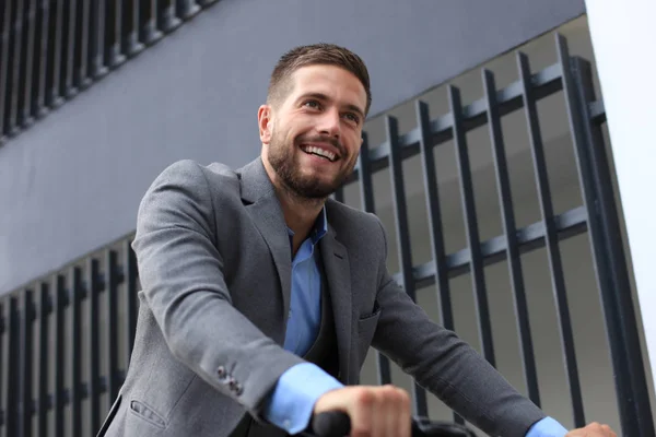 Guapo joven hombre de negocios montar en bicicleta al aire libre en la ciudad . —  Fotos de Stock