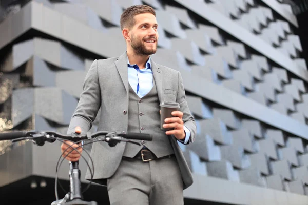 屋外コーヒーを飲む彼の自転車に自信を持って若いビジネスマン. — ストック写真