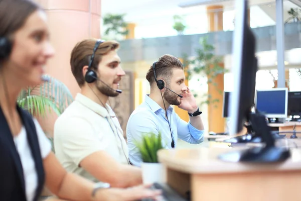 Atractivos jóvenes empresarios y colegas positivos en una oficina de call center. —  Fotos de Stock