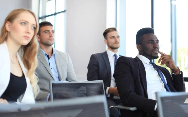 Grupo de hombres de negocios sentados en conferencia a discurso durante una reunión de negocios . — Foto de Stock