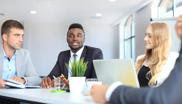 Empresários discutem algo enquanto se sentam juntos à mesa . — Fotografia de Stock