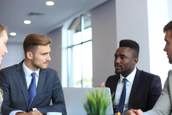 Mensen uit het bedrijfsleven bij het bespreken van iets samen aan tafel zittend. — Stockfoto