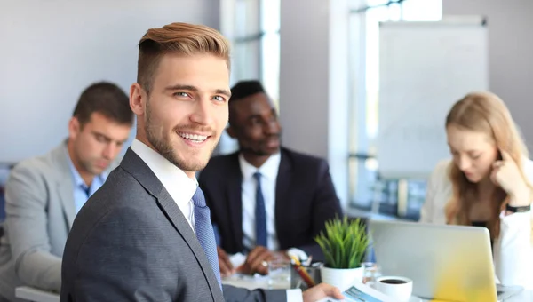 Empresario con colegas en segundo plano en la oficina. — Foto de Stock