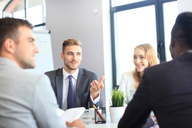 Birlikte masada otururken bir şey tartışırken iş adamları.