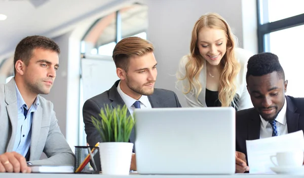 Inicie el equipo de negocios en la reunión en el interior de la oficina brillante moderna y trabajando en el ordenador portátil. —  Fotos de Stock