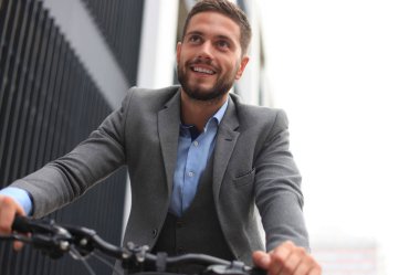 Yakışıklı genç işadamı binicilik bisiklet açık havada şehirde.