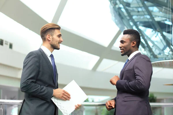 Dos jóvenes empresarios multinacionales discuten negocios en reunión en el cargo . —  Fotos de Stock