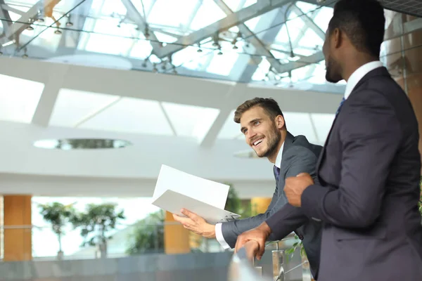 Dos jóvenes empresarios multinacionales discuten negocios en reunión en el cargo . — Foto de Stock