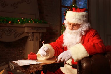 Mutlu Noel Baba 'nın portresi Noel ağacının yanındaki odasında oturuyor ve Noel mektuplarına cevap veriyor..