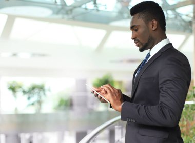 Akıllı telefon üzerinde e-posta okuma başarılı bir Afrikalı-Amerikalı iş adamı.