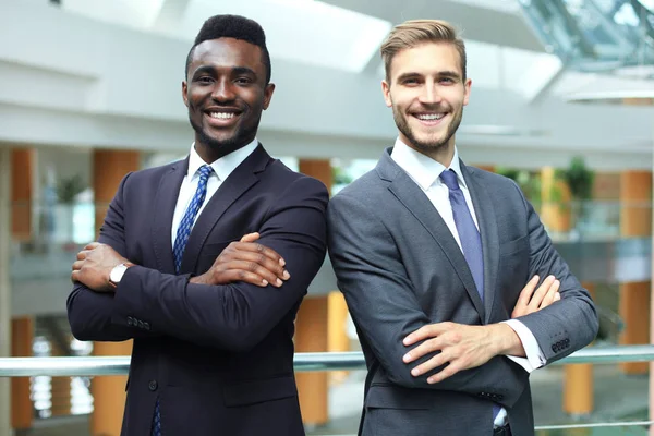 Partner commerciali afro-americani e caucasici che si ritrovano insieme e guardano davanti alla telecamera, in ufficio . — Foto Stock