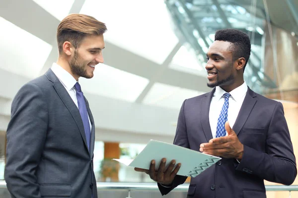 Dos jóvenes empresarios multinacionales discuten negocios en reunión en el cargo . —  Fotos de Stock