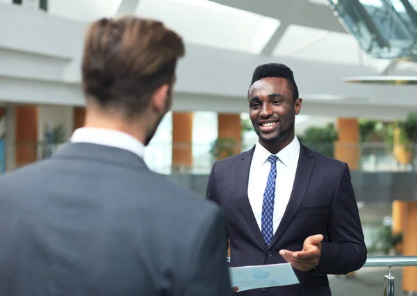 Zwei multinationale Jungunternehmer diskutieren bei einem Treffen im Büro über Geschäfte. — Stockfoto